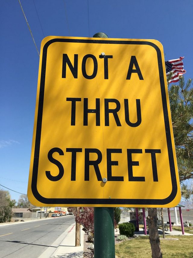 A street sign with the word "Thru"