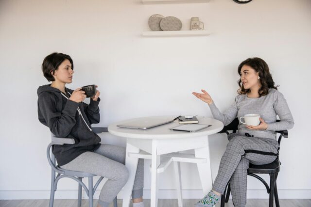 Two women chat casually over coffee.