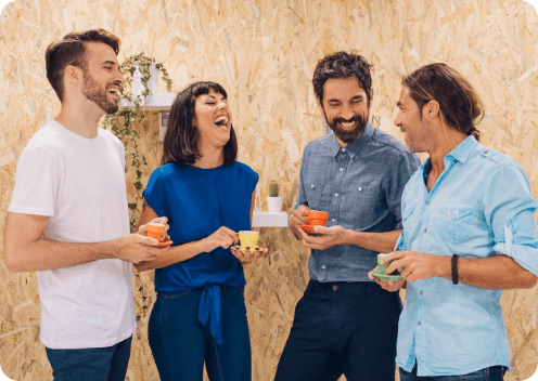 A group of people laughing and holding cups