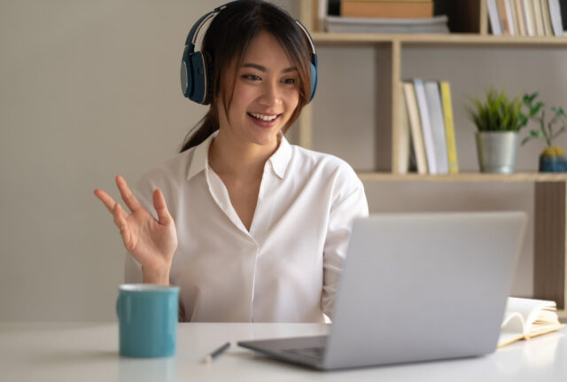 A woman greets her coach on her laptop