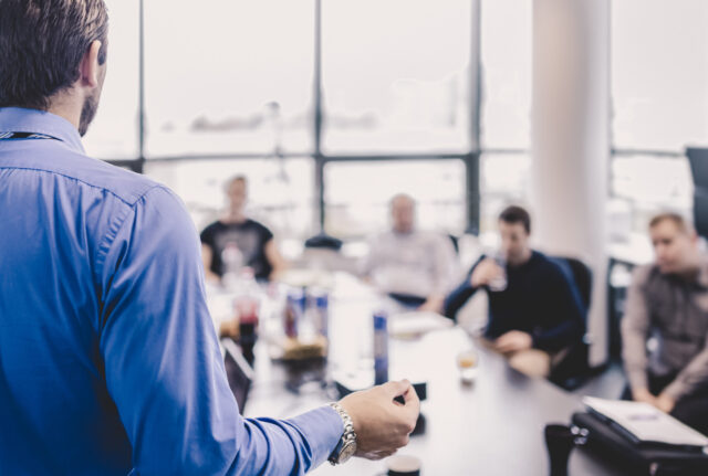 A man nervously presents to a boardroom.
