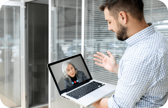 a man holding a laptop with a woman on the screen