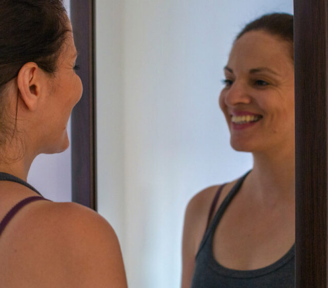 Young woman smiles in the mirror
