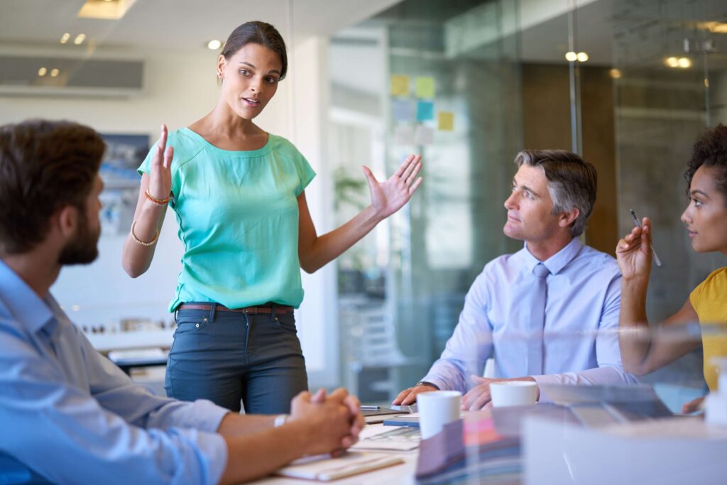 Business meeting where a woman present in front of 3 other employees